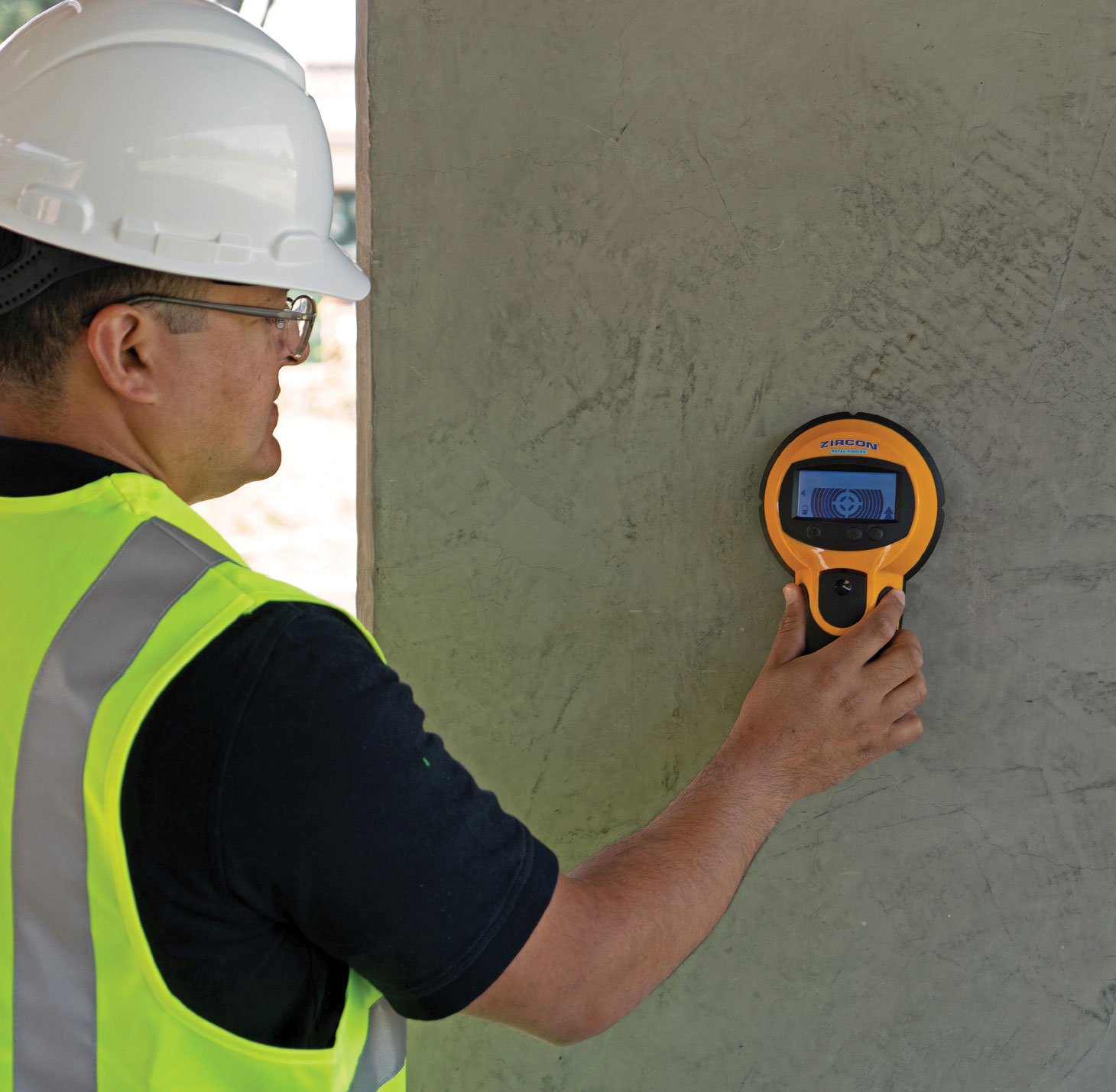 Worker scanning concrete wall