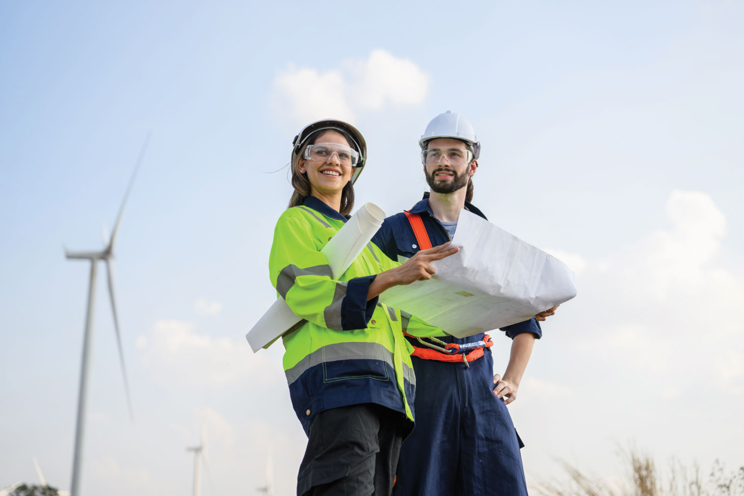 Two workers in safety equipment smiling