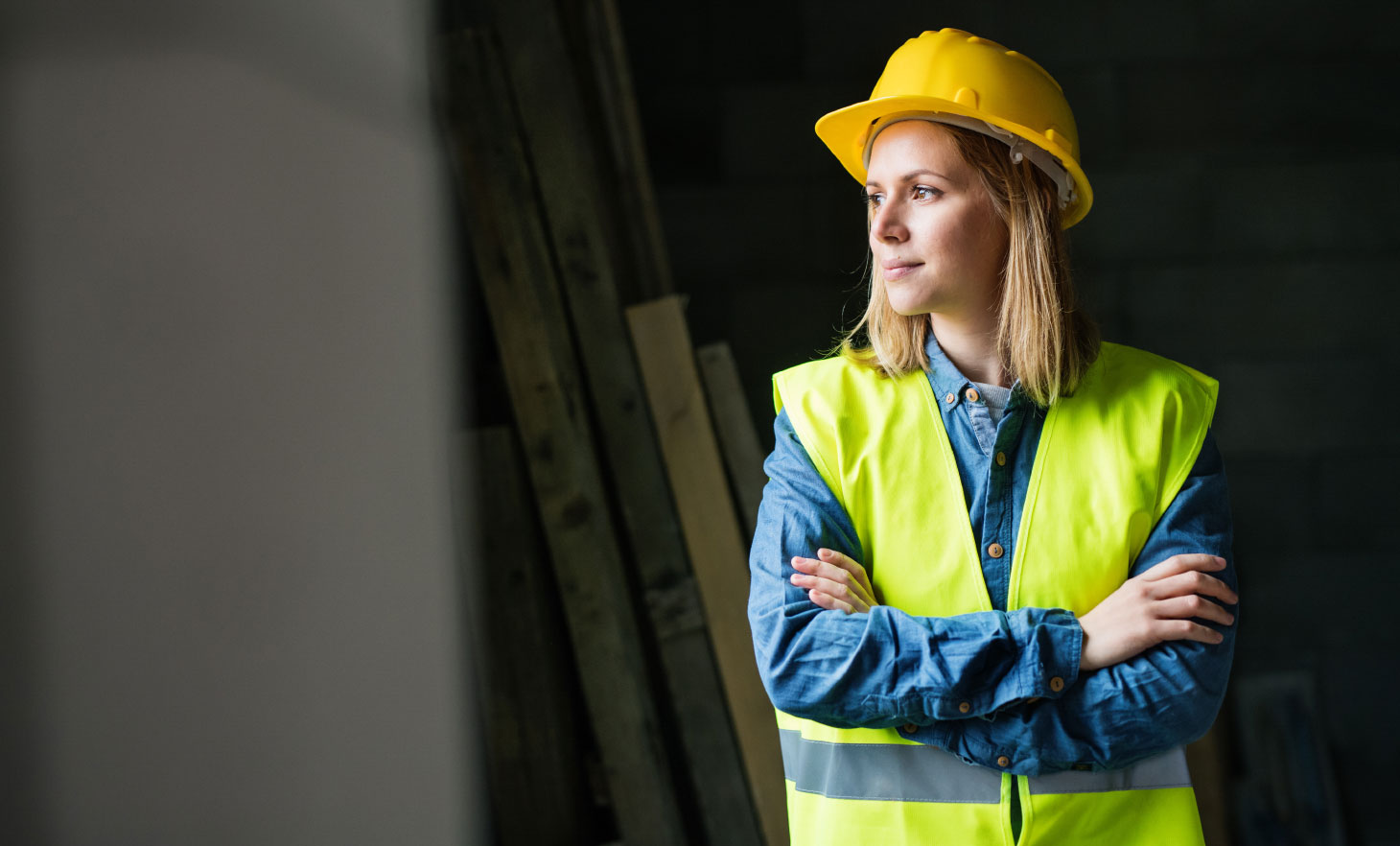 Woman standing with arms crossed wearing PPE equipment