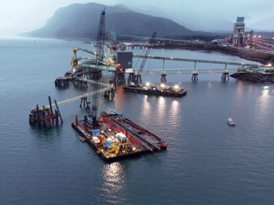 Heavy equipment on barge at dusk in heavy fog