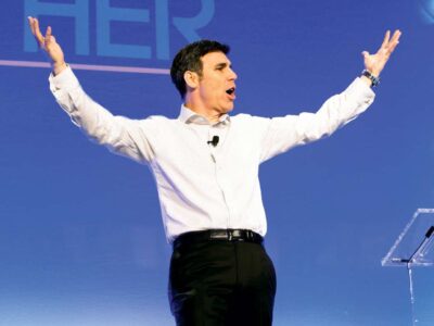 Garrison Wynn with arms in air on stage