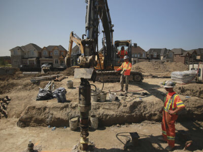 Workers and heavy equipment operating on construction site