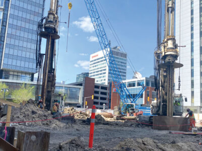 Foundation construction with commercial buildings in background