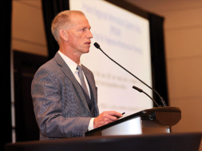 John Law speaking in mic at podium