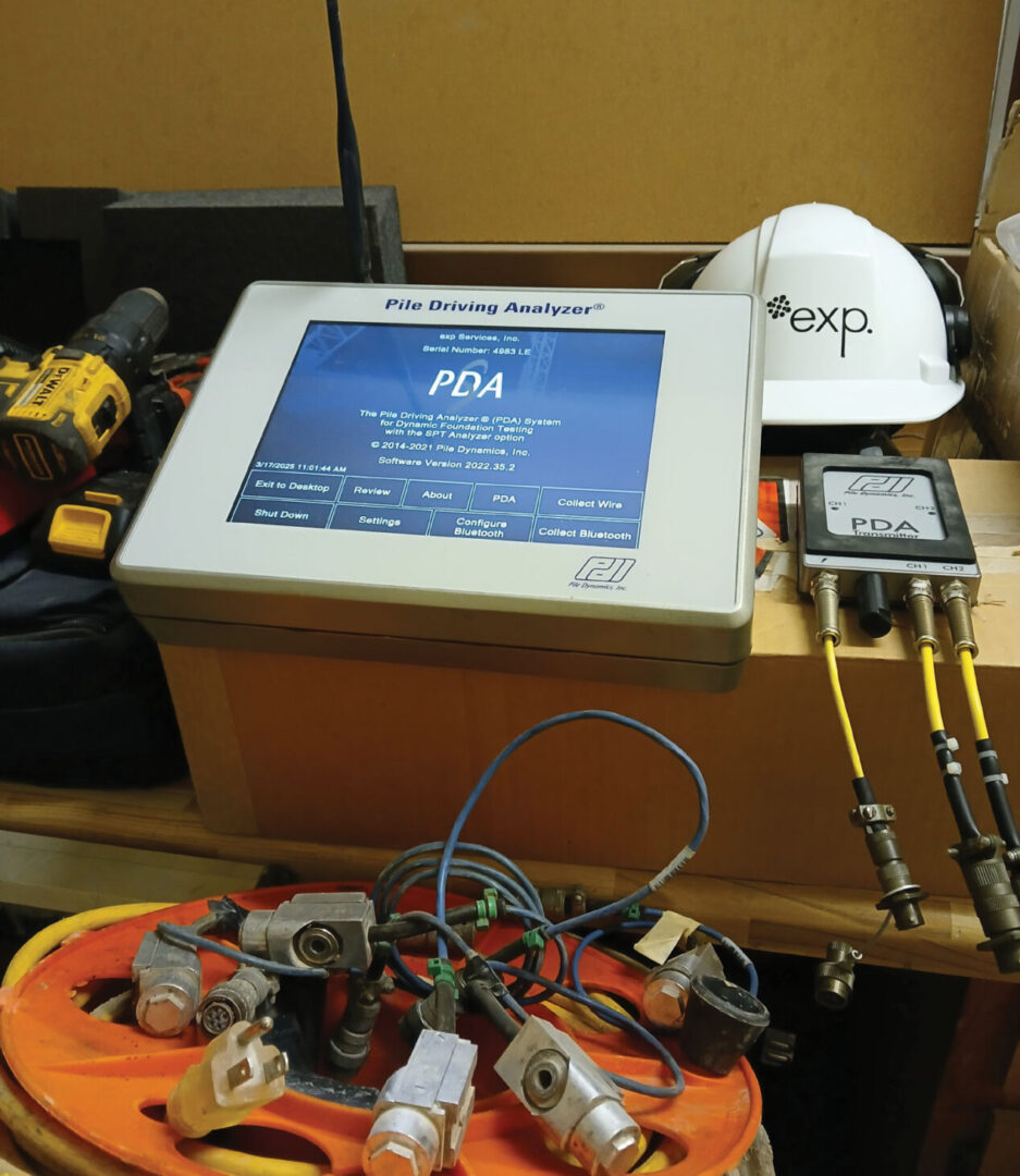 PDA testing device on tablew with white hardhat in background