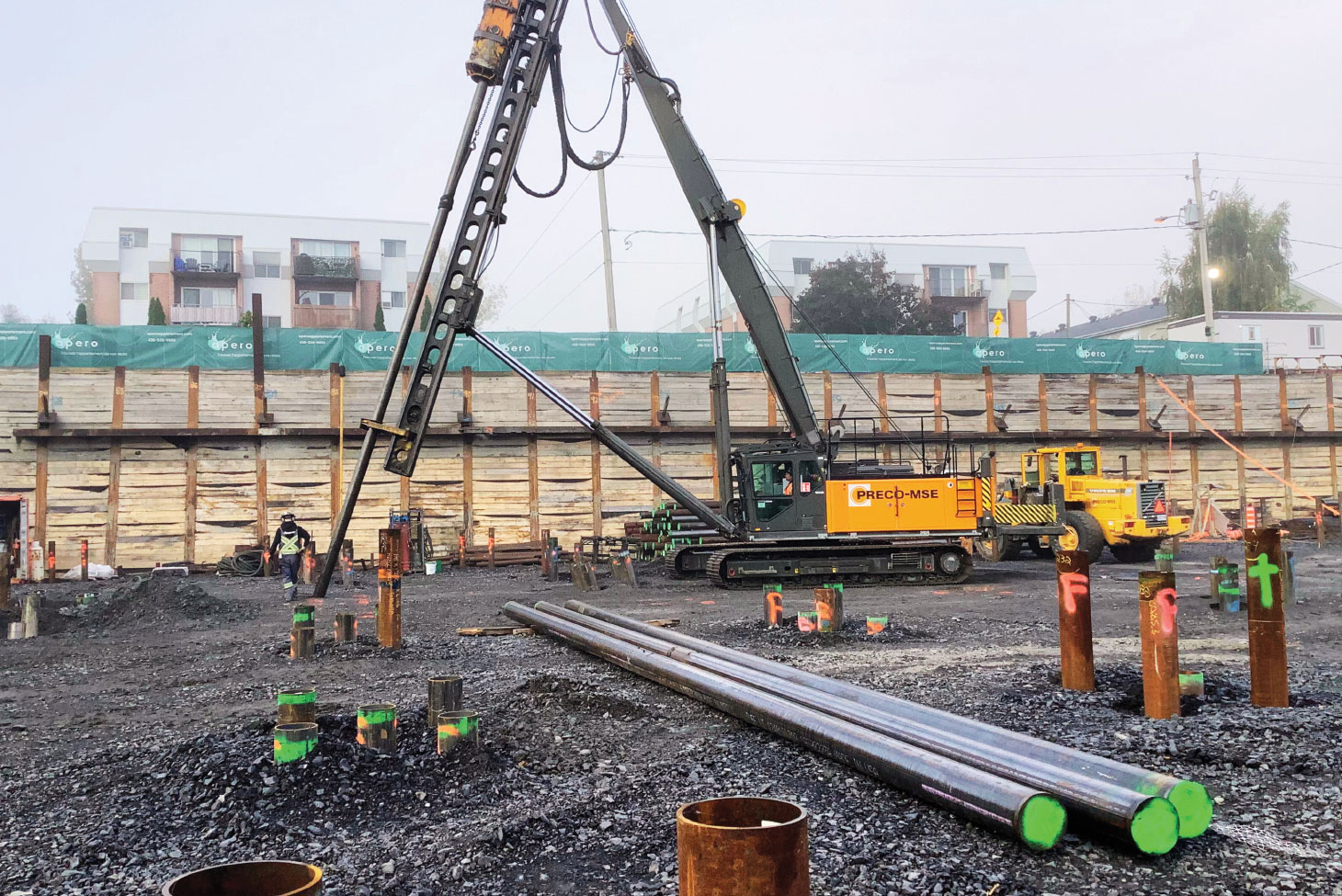 Workers and drilling rigs on construction site
