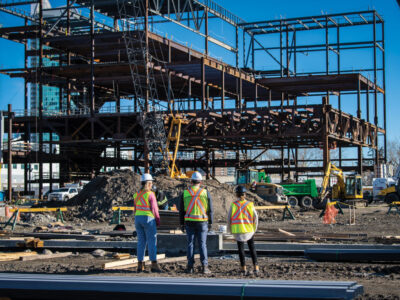 Workers in PPE overlooking construction site