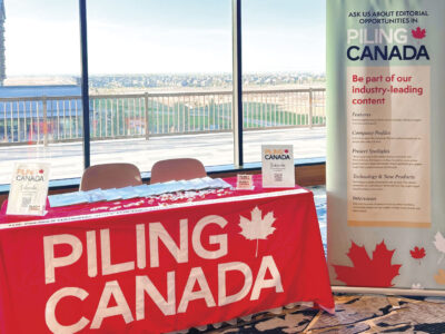 Conference table with Piling Canada logo draped over it along with tall advertising banner