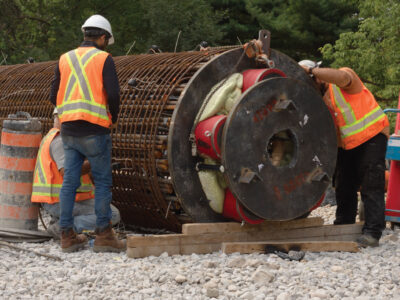 Workers in PPE vests and hardhats on construction site