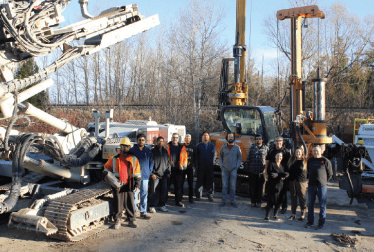 Staff photo in front of heavy equipment