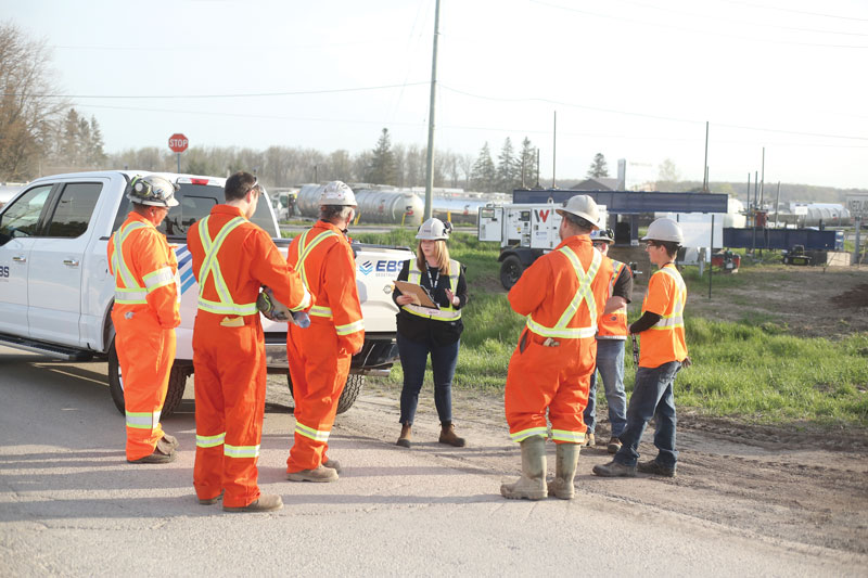Work crew gathered on road for briefing
