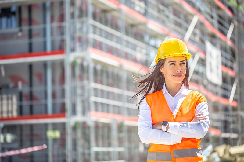 Woman in PPE on construction site.
