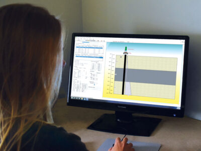 Woman reviewing technical data on computer monitor