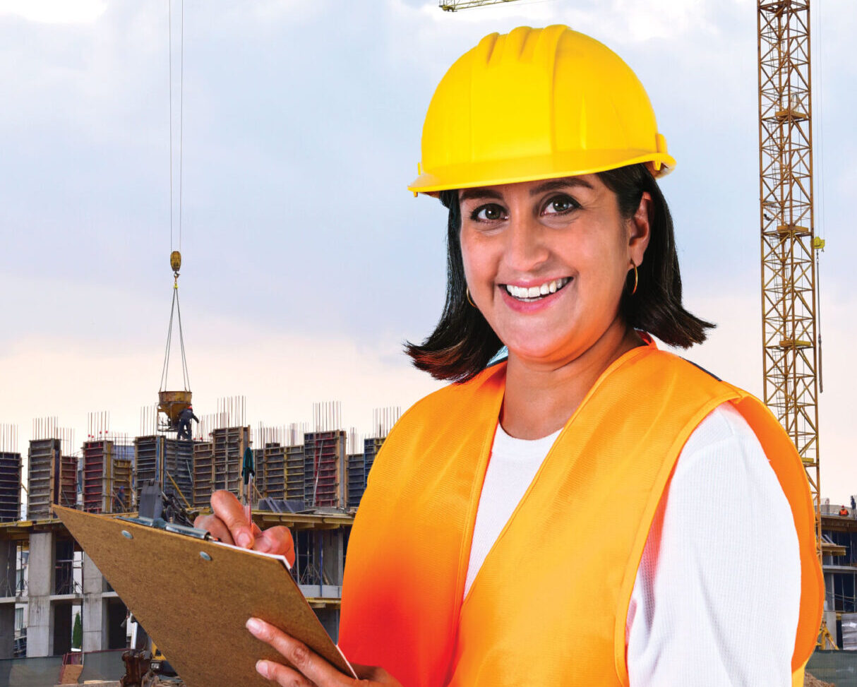 Woman in safety gear holding clipboard on construction site