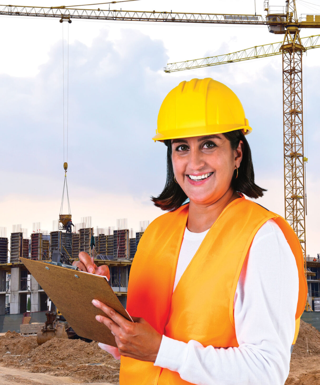 Woman in safety gear holding clipboard on construction site