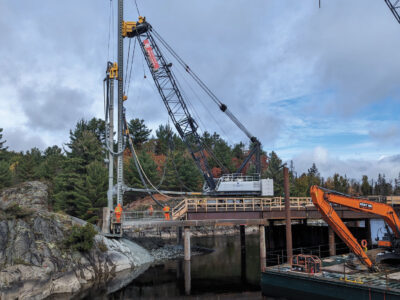 Heavy equipment driving piles at Nairn Falls generating system
