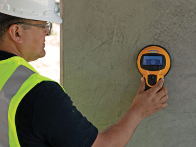Worker scanning concrete wall
