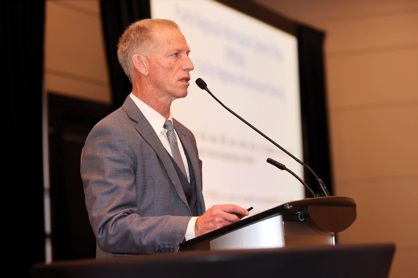 John Law speaking in mic at podium