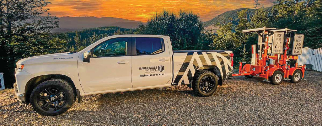 Pickup truck with Barricades and Signs branding with sun setting in background
