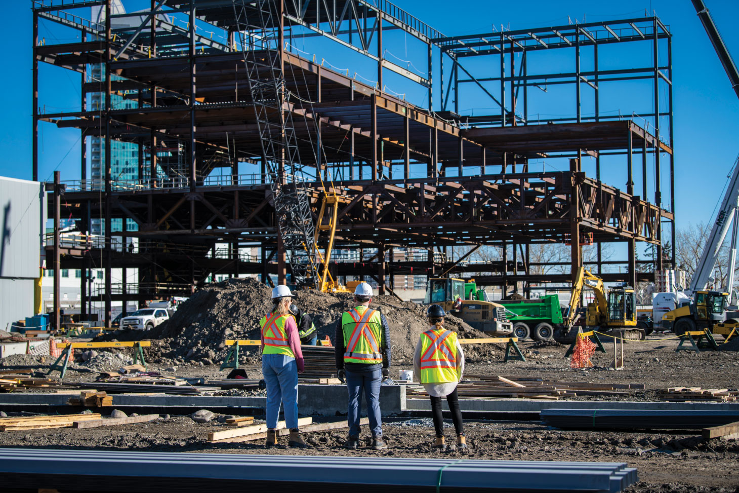 Workers in PPE overlooking construction site