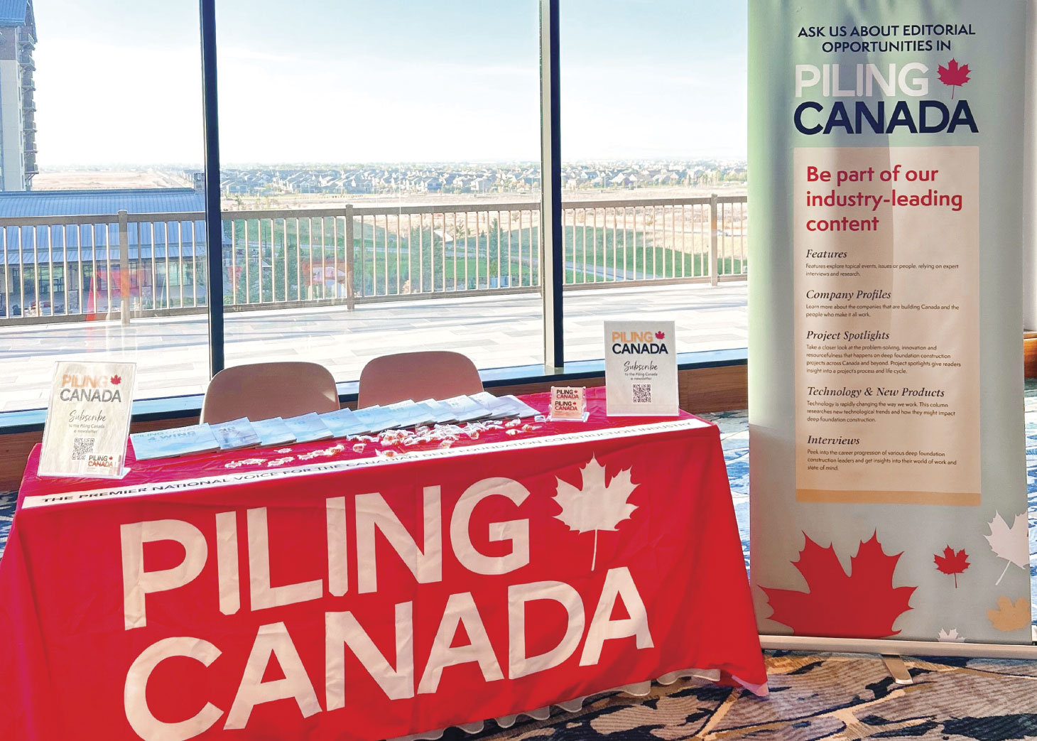 Conference table with Piling Canada logo draped over it along with tall advertising banner