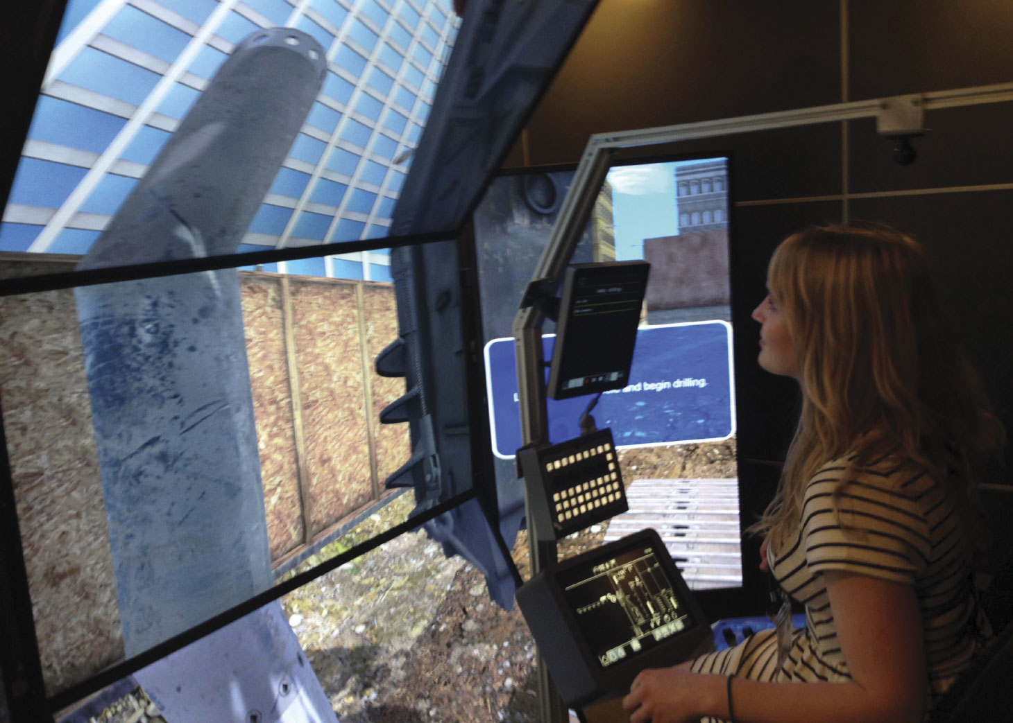 Jill Harris seated in a drilling simulator looking at multiple displays