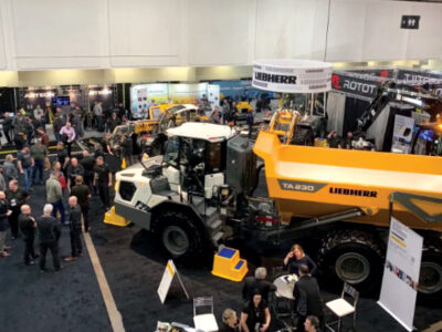 Showroom floor full of people and heavy machinery