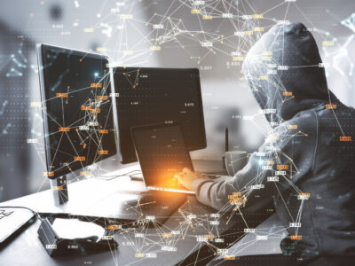Hacker at table using computers with creative glowing big data connections circle on blurry interior background