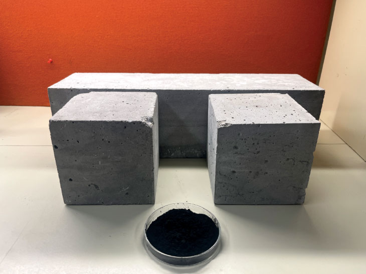 Concrete beam and two cubes along with biochar powder in dish