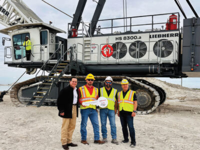 Justin Sobie, Patrick Ryan, Marc Barnell and Wolfgang Herzog standing in front of Leibherr 8300.2 crane