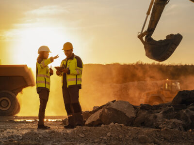 Workers on job site having dicussion, with sun setting in background