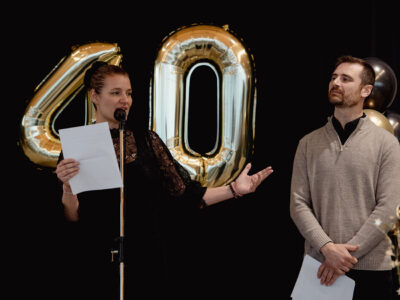 Audrey and Frank Gilbert on stage, addressing crowd