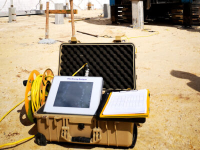 Pile driving analyzer testing in construction site with cloudy sky