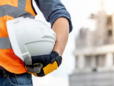 Male holding white hard hat under arm