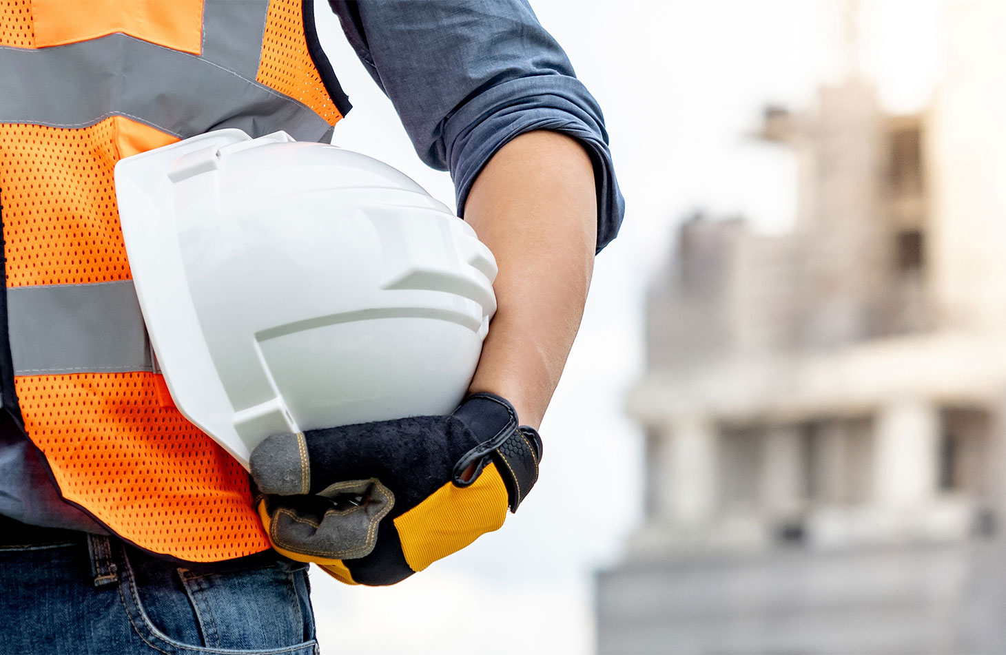 Male holding white hard hat under arm